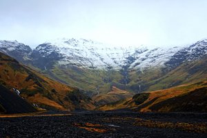 Snow-capped mountain range in Akranes, showcasing the beauty of nature's peaks against a clear blue sky